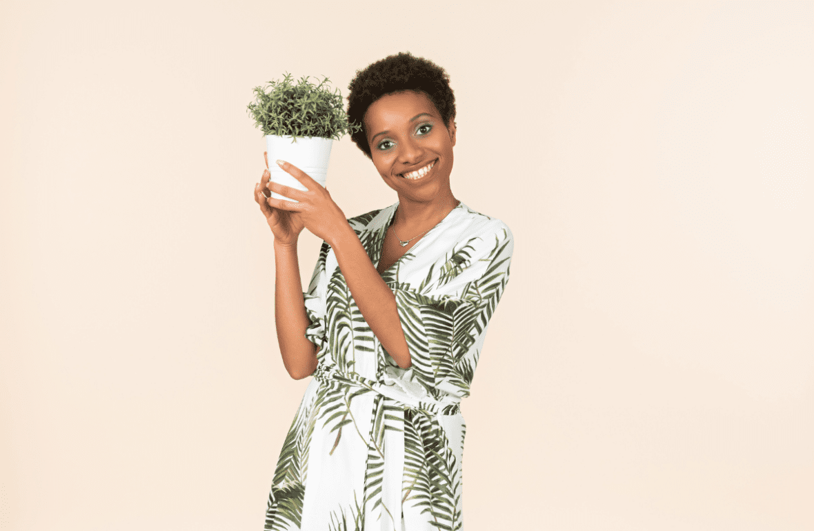 Mulher feliz com um vaso de planta. Imagem ilustrativa para texto comprar plantas pela internet.