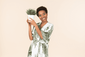 Mulher feliz com um vaso de planta. Imagem ilustrativa para texto comprar plantas pela internet.